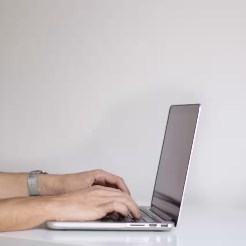 mains posées sur le clavier d'un ordinateur portable.